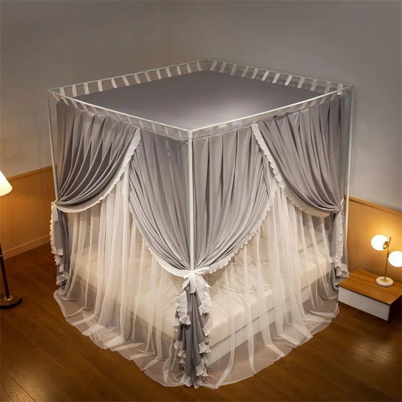 Un lit à baldaquin élégant et spacieux, avec des rideaux gris et blancs suspendus à une structure métallique, créant une atmosphère chaleureuse et intime dans la chambre.