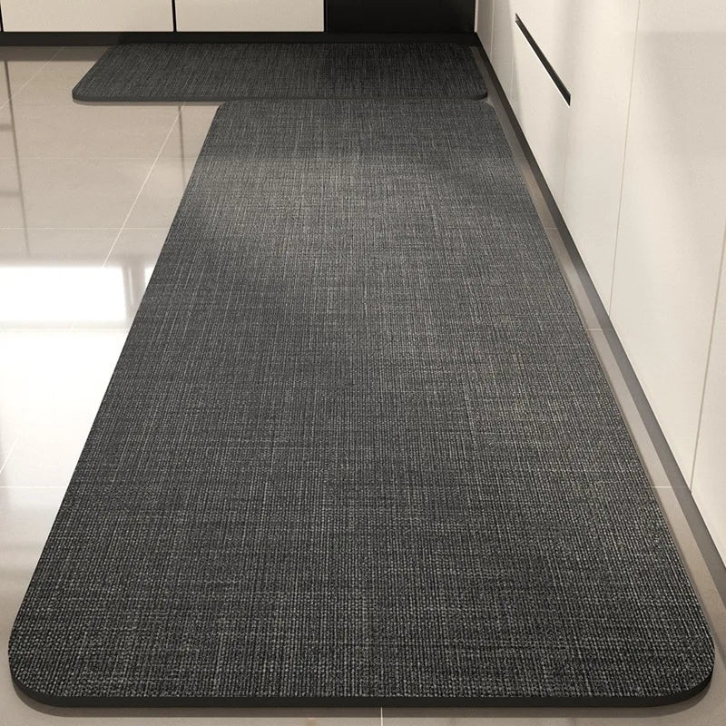 Tapis rectangulaire gris texturé, posé sur un sol blanc, qui s'étend sur toute la longueur de la pièce.