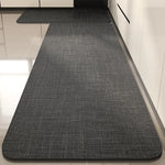 Tapis rectangulaire gris texturé, posé sur un sol blanc, qui s'étend sur toute la longueur de la pièce.