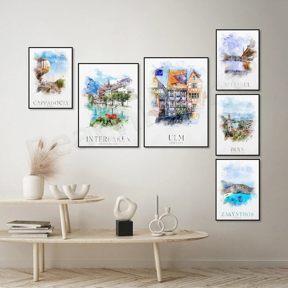 Une collection d'affiches aquarelles représentant des paysages de villes et de destinations touristiques, comme Cappadoce, Interlaken, Ulm, Istanbul et Berne, créant une ambiance chaleureuse et voyageuse dans la pièce.
