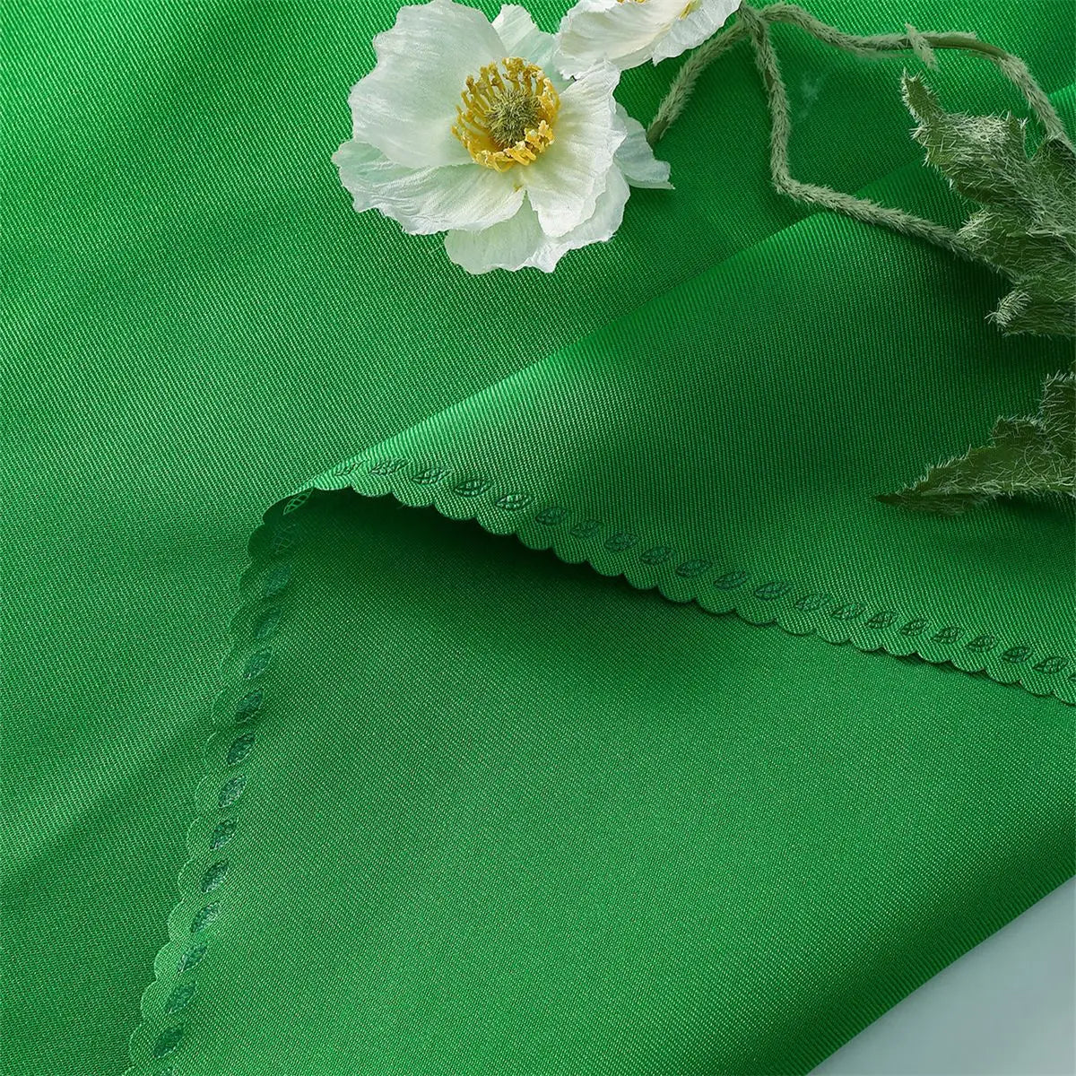 Une magnifique fleur blanche épanouie posée sur un fond vert vibrant, rehaussée par des détails texturés captivants.