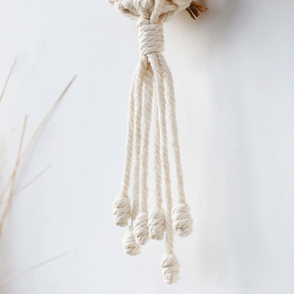 Composition déco avec plusieurs porte-plantes muraux en macramé