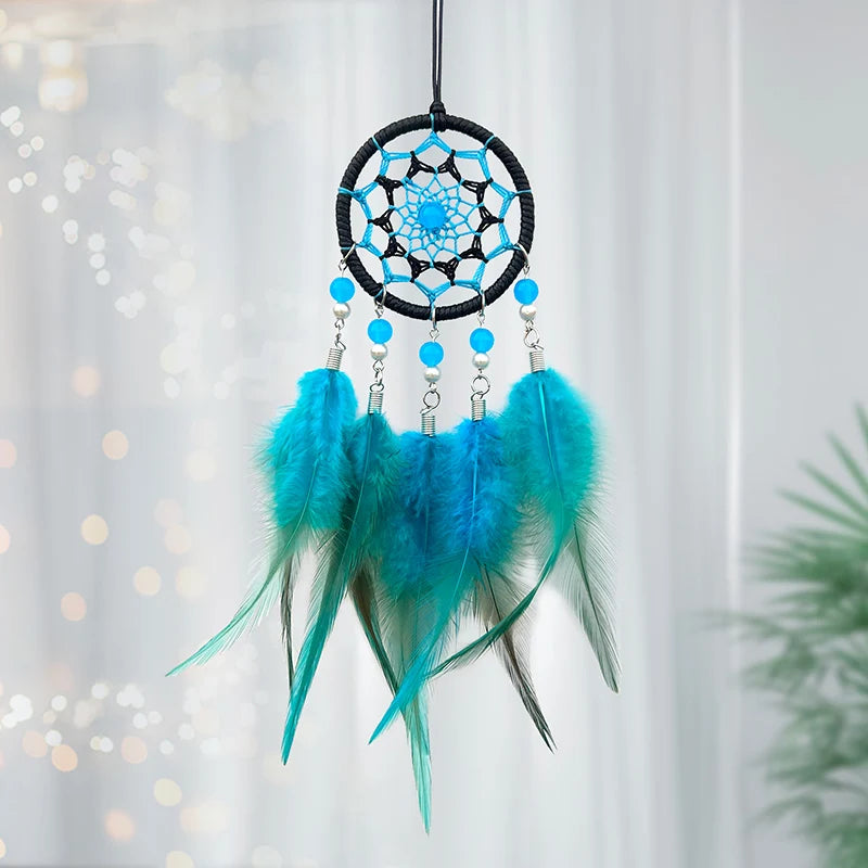 Le rêve-capteur bleu et turquoise aux plumes souples et brillantes accrochées à un anneau en filet tissé est un accessoire décoratif attrayant.