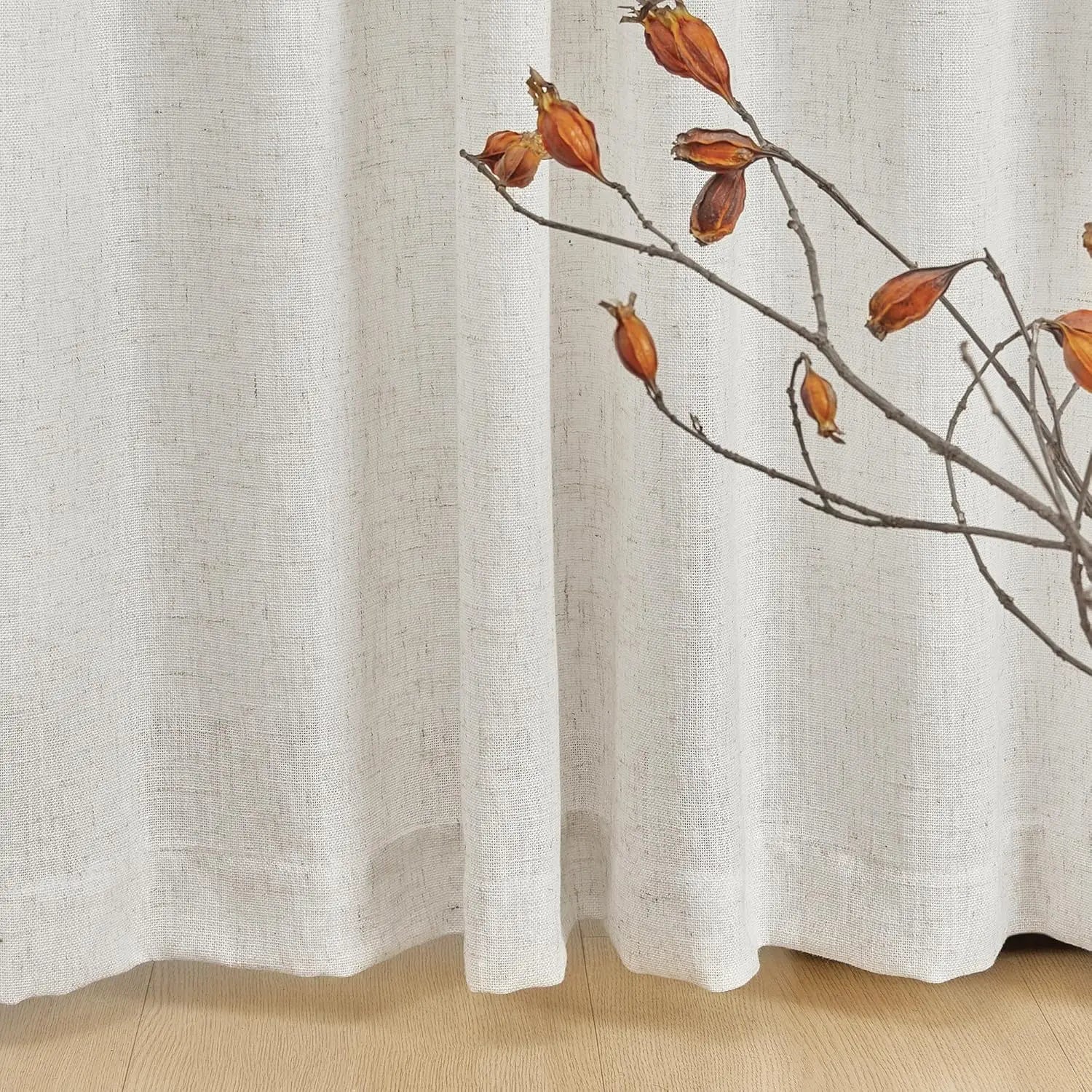 Rideau beige élégant avec branches décoratives sèches et sol en bois clair, parfait pour ajouter une touche naturelle à votre intérieur tout en préservant votre intimité.