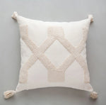 Coussin décoratif blanc avec des motifs en relief en forme de losanges en beige.