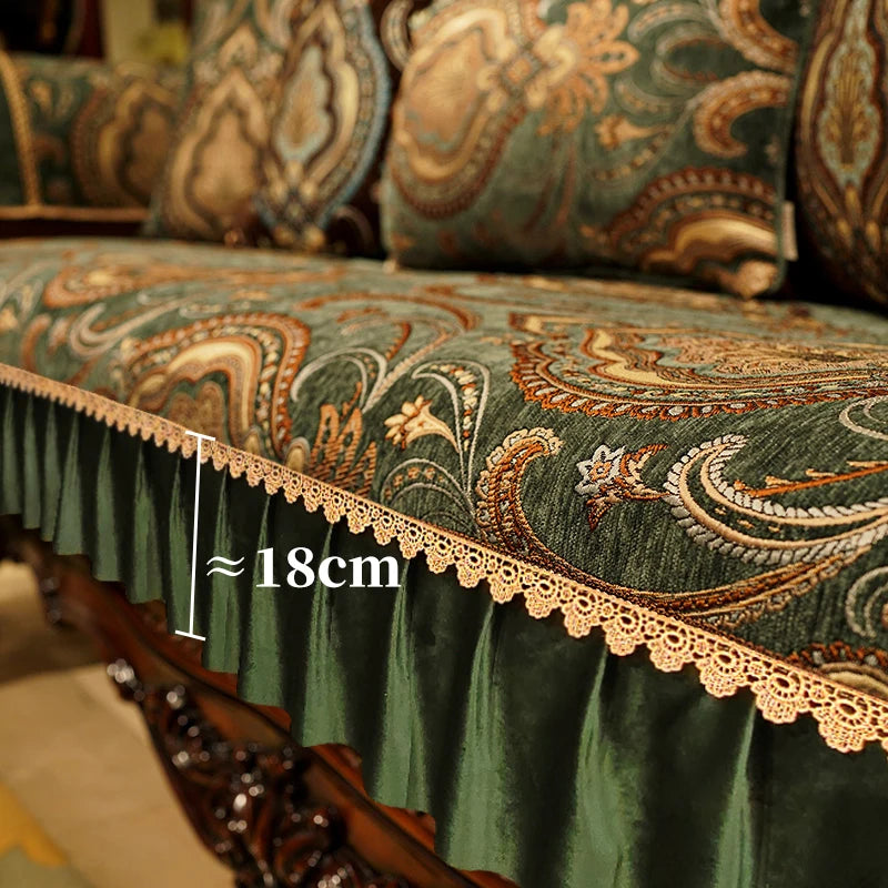 Un magnifique tissu d'ameublement aux motifs floraux et paisley dans des teintes de vert et de doré, avec une frange en dentelle soulignant le bord.