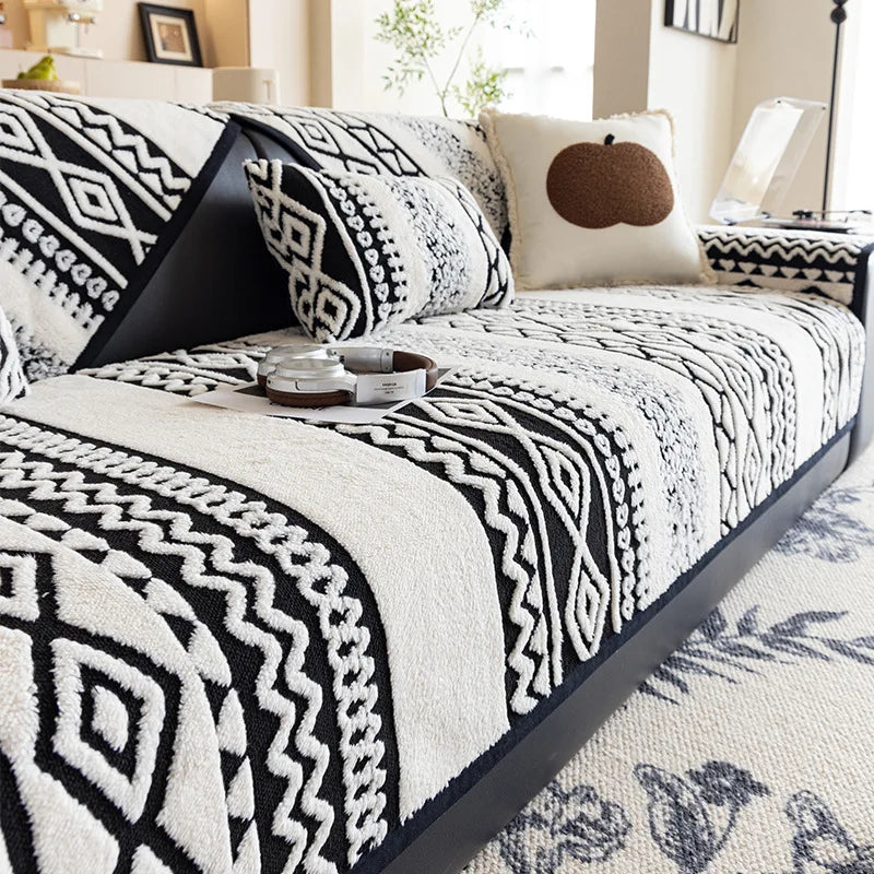 Un lit douillet avec une couverture monochromatique noire et blanche, aux motifs graphiques géométriques élégants, créant une ambiance chaleureuse et moderne dans cette pièce.