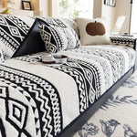 Un lit douillet avec une couverture monochromatique noire et blanche, aux motifs graphiques géométriques élégants, créant une ambiance chaleureuse et moderne dans cette pièce.