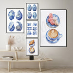 Une collection d'illustrations de coquillages bleu et blanc, de tasses à café en porcelaine, ainsi que de délicieux macarons et de cafés au latte sur des assiettes en porcelaine décorées.