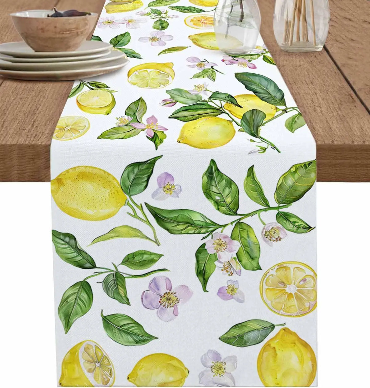 Une nappe blanche ornée de citrons jaunes, de feuillage vert et de délicates fleurs violettes, évoquant une ambiance fraîche et printanière.