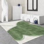 Un tapis moderne et texturé, avec des formes abstraites et des teintes de vert, dans un intérieur épuré et minimaliste.