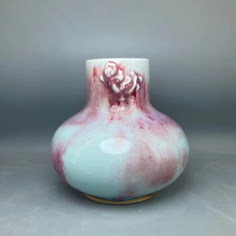 Vase décoratif en céramique de couleur turquoise et rose, orné d'un design floral élégant.
