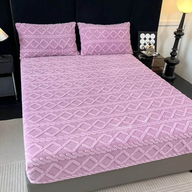 Couverture de lit rose pâle de style contemporain avec un motif géométrique répété sur toute la surface.