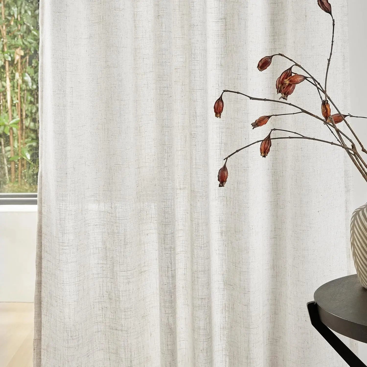 Rideau élégant dans un intérieur moderne avec décoration végétale séchée. Idéal pour apporter une touche naturelle et apaisante à votre salon. Fenêtre avec vue sur un jardin verdoyant. Accessoire incontournable pour l'aménagement de votre espace de vie.