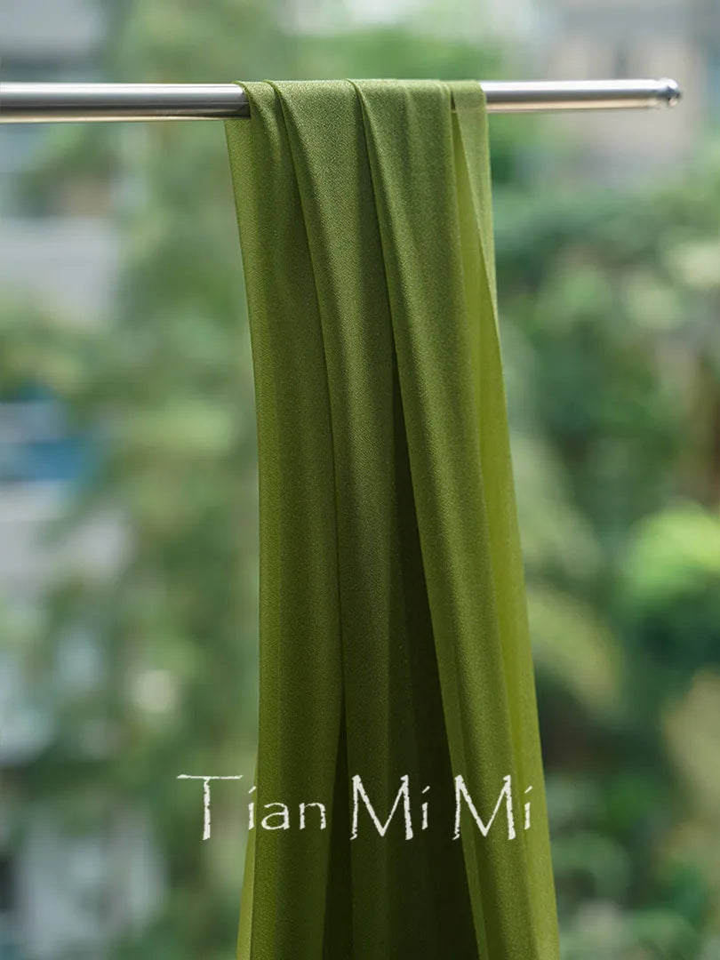 Une serviette verte suspendue sur une barre métallique avec l'inscription "Tian Mi Mi" imprimée.
