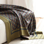 Plaid vert et gris motif géométrique posé sur lit