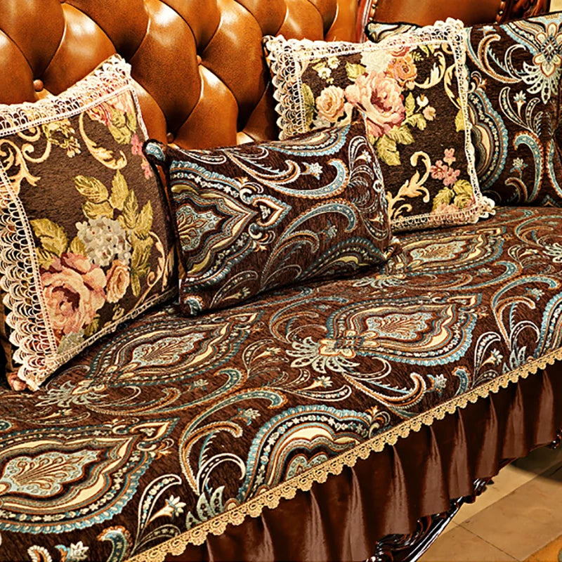 Coussins décoratifs colorés sur un canapé richement orné de motifs floraux et paisley.