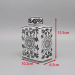 Un pot de céramique décoré d'un motif floral noir et blanc.