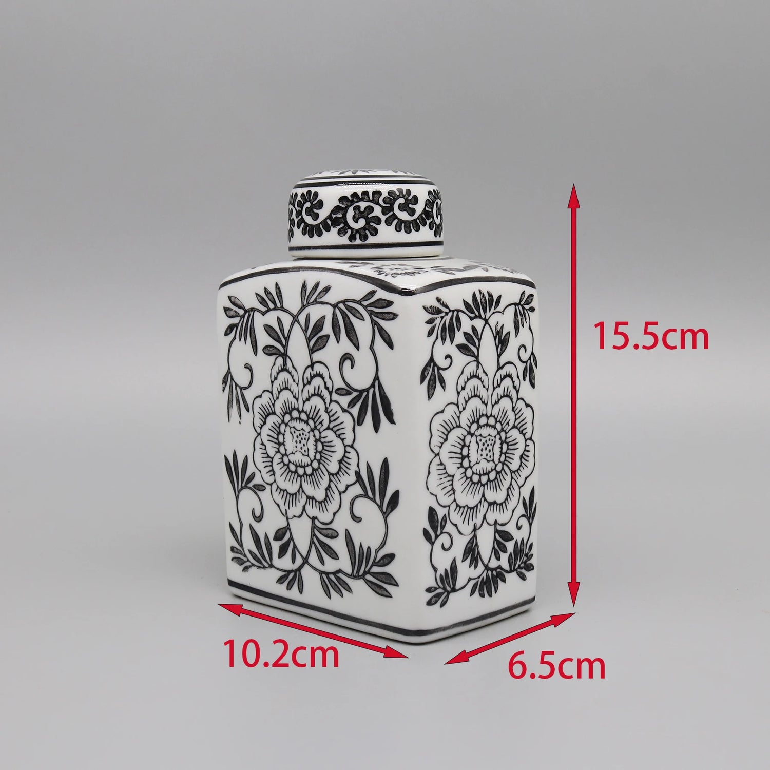 Un pot de céramique décoré d'un motif floral noir et blanc.