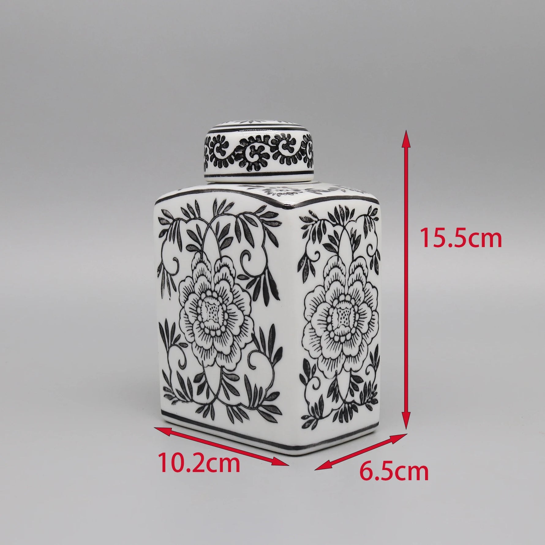 Un pot de céramique décoré d'un motif floral noir et blanc.