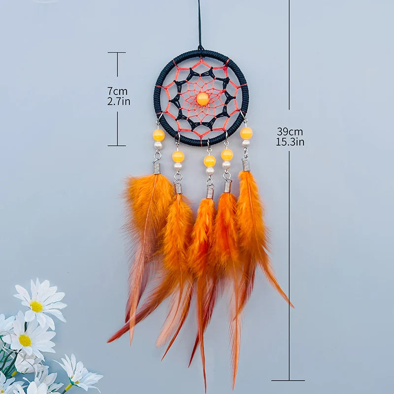 Un capteur de rêves orange en macramé, avec des perles jaunes et des plumes oranges pendantes, mesurant 39 cm de longueur.