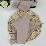Nappe en fibres tressées, avec des serviettes de table assorties en lin beige.