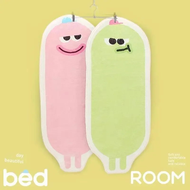 Des coussins décoratifs en forme de personnages souriants dans des tons rose et vert, accrochés au mur, formant l'inscription "Bed Room".
