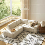 canapé d'angle moderne beige clair uni confortable salon minimaliste inclusion coussins tapis