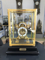 horloge décorative vintage verre métal doré transparent socle noir nom gravéintérieur mécanisme visible salon