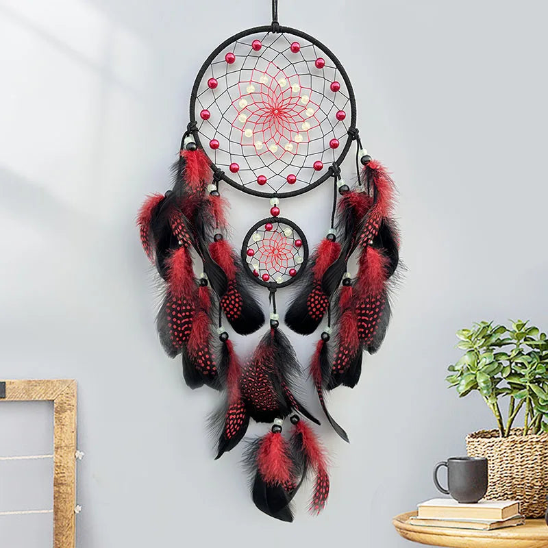 Un captivant attrape-rêves en noir et rouge, orné de plumes aux motifs géométriques et de perles scintillantes, crée une atmosphère mystique et méditative dans la pièce.