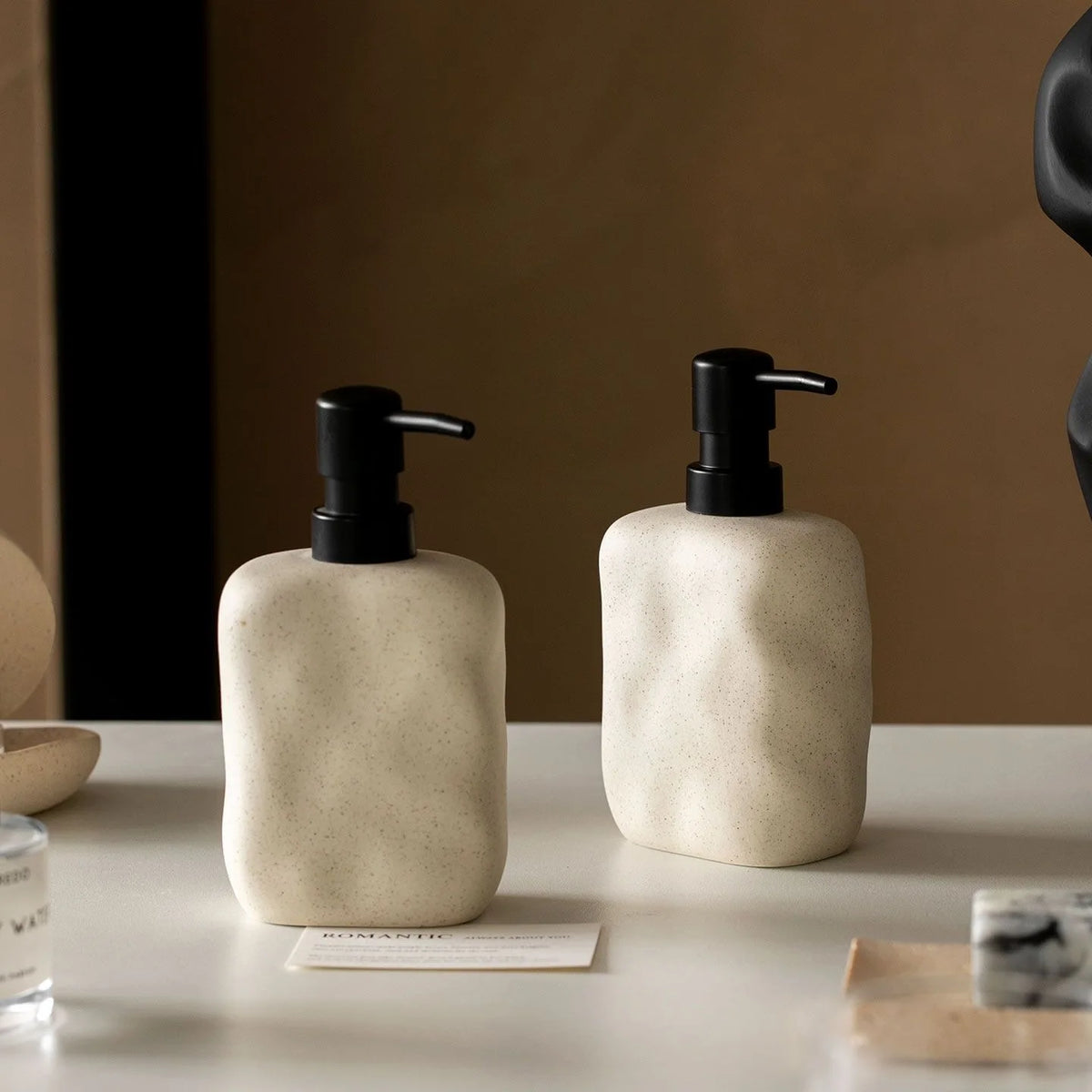 distributeur savon liquide céramique beige texture granulée minimaliste accessoire salle bains après shampooing lotion