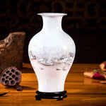 Vase en porcelaine blanche avec un motif hivernal de paysage enneigé et de maisons.