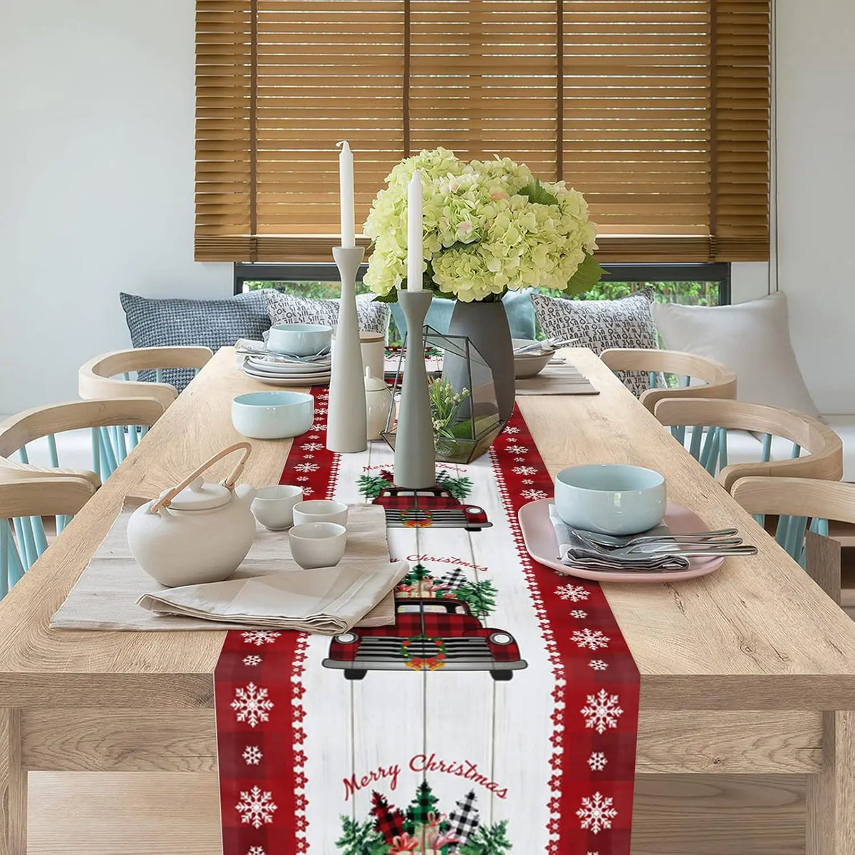 Une table de salle à manger décorée avec des bougies, des fleurs et des accessoires de Noël, créant une ambiance festive.