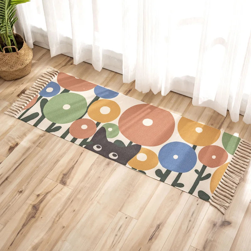 Tapis décoratif aux motifs géométriques colorés sur un parquet clair, avec un pot de plante en fibre naturelle dans le coin.