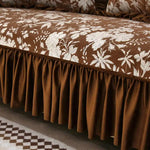 Une couverture de lit élégante et florale aux nuances de brun et de blanc, avec un bord plissé brun qui lui confère un style sophistiqué.