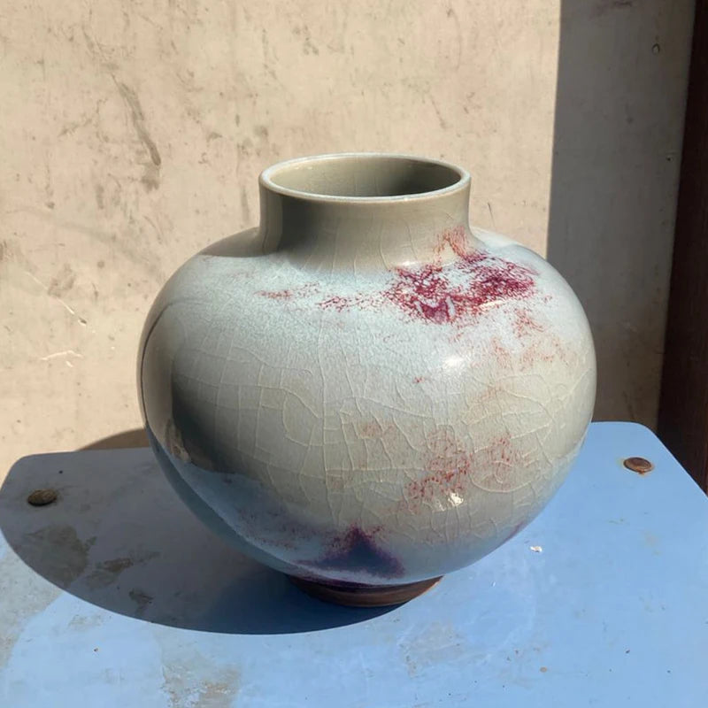 Vase en céramique de couleur bleu-vert avec de jolies taches rouges et craquelures, créé par un artisan céramiste talentueux.