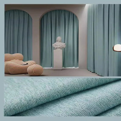 Des rideaux bleus, suspendus à une fenêtre, apportant une texture textile douce et naturelle à la décoration intérieure, semblable à un papier peint de luxe. Les rideaux en polyester, un matériau naturel, créent une atmosphère chaleureuse et accueillante dans la pièce.
