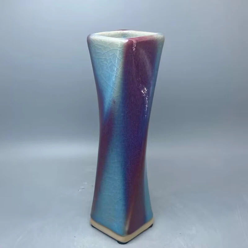 Un vase en céramique de forme conique aux couleurs dégradées bleu et violet, créant un effet visuel captivant.