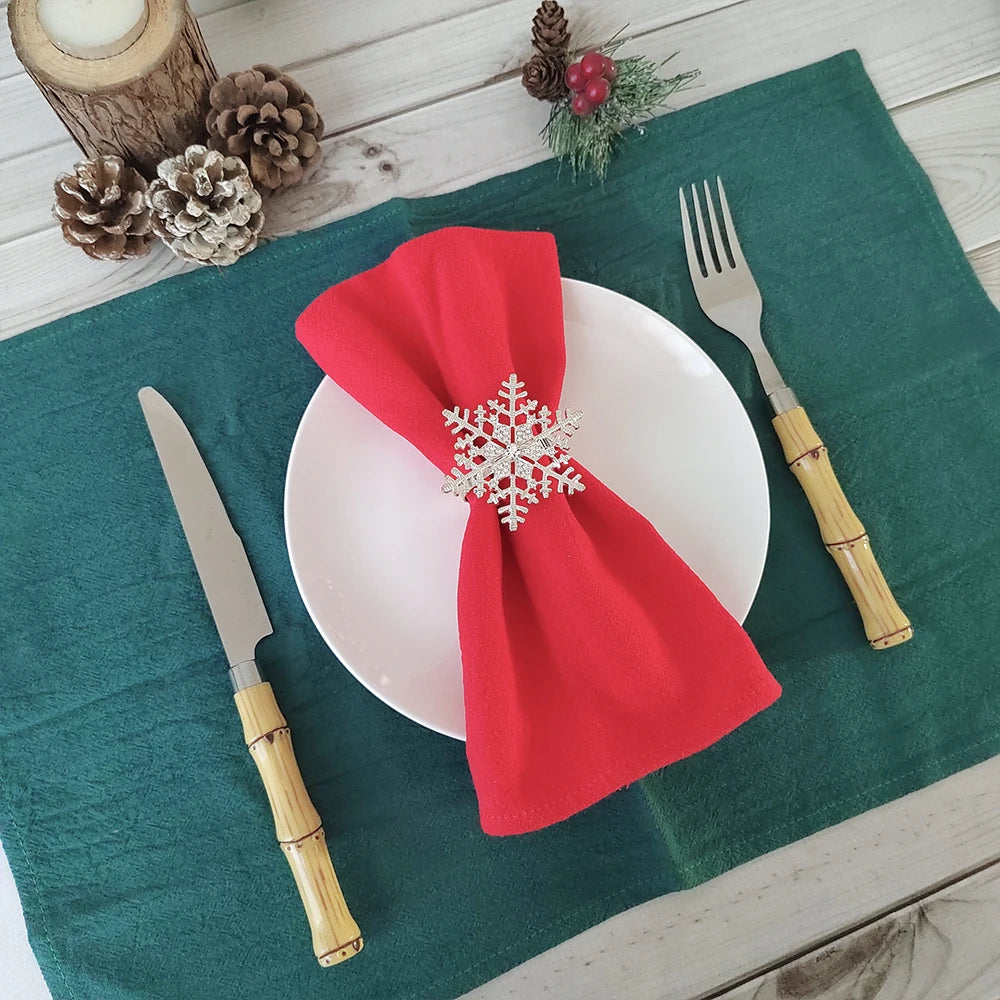 Une table de Noël décorée avec des serviettes rouges et des ornements d'hiver.