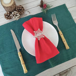 Une table de Noël décorée avec des serviettes rouges et des ornements d'hiver.
