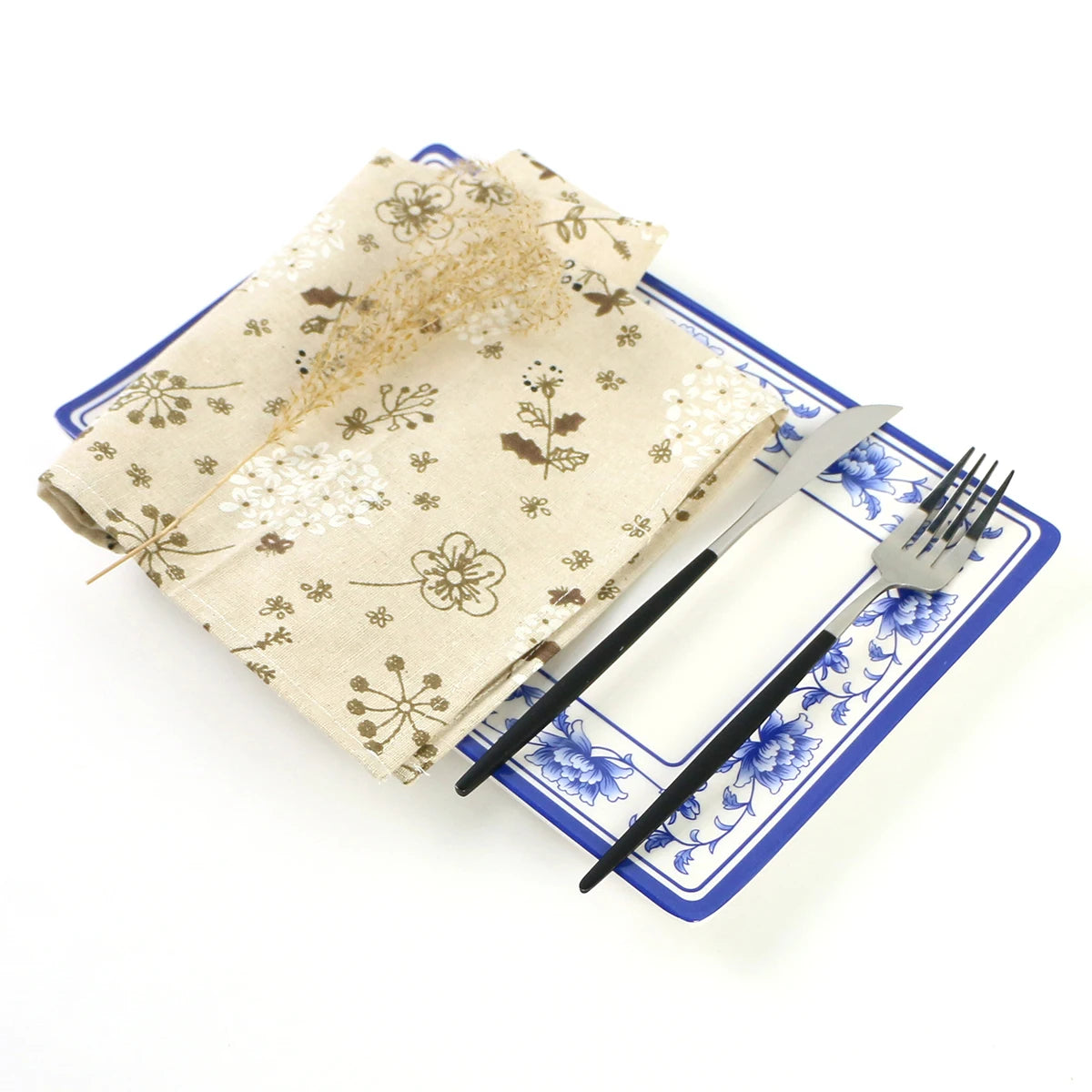Un ensemble de vaisselle japonaise avec un motif floral beige et des éléments bleus, comprenant une assiette et des couverts.