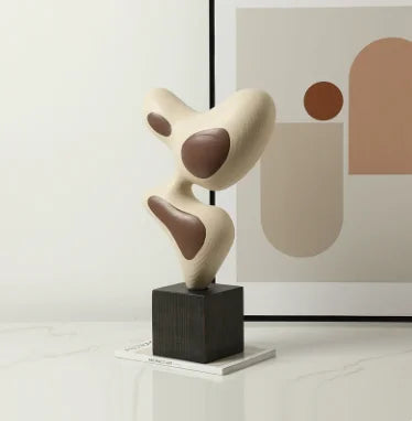 sculpture décorative résine forme abstraite moderne minimaliste beige marron foncé posée socle bois sombreintérieur