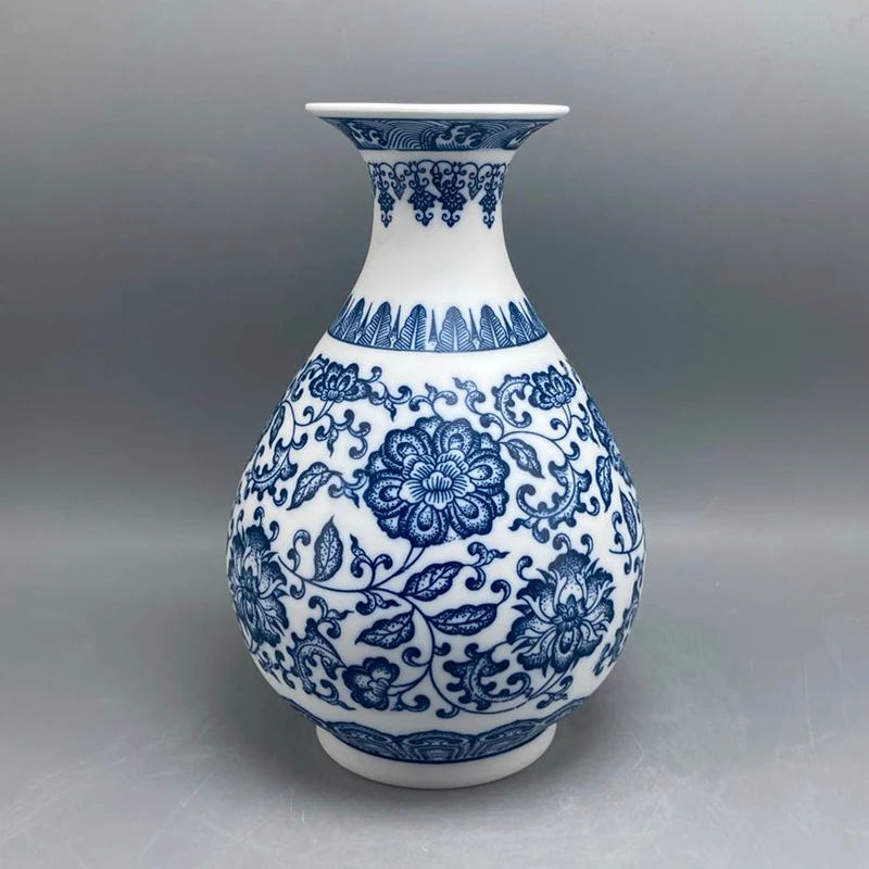 Vase en porcelaine blanche et bleue décoré de motifs floraux complexes et de motifs abstraits, créant un design élégant et traditionnel.