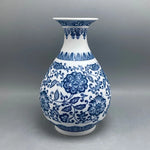 Vase en porcelaine blanche et bleue décoré de motifs floraux complexes et de motifs abstraits, créant un design élégant et traditionnel.