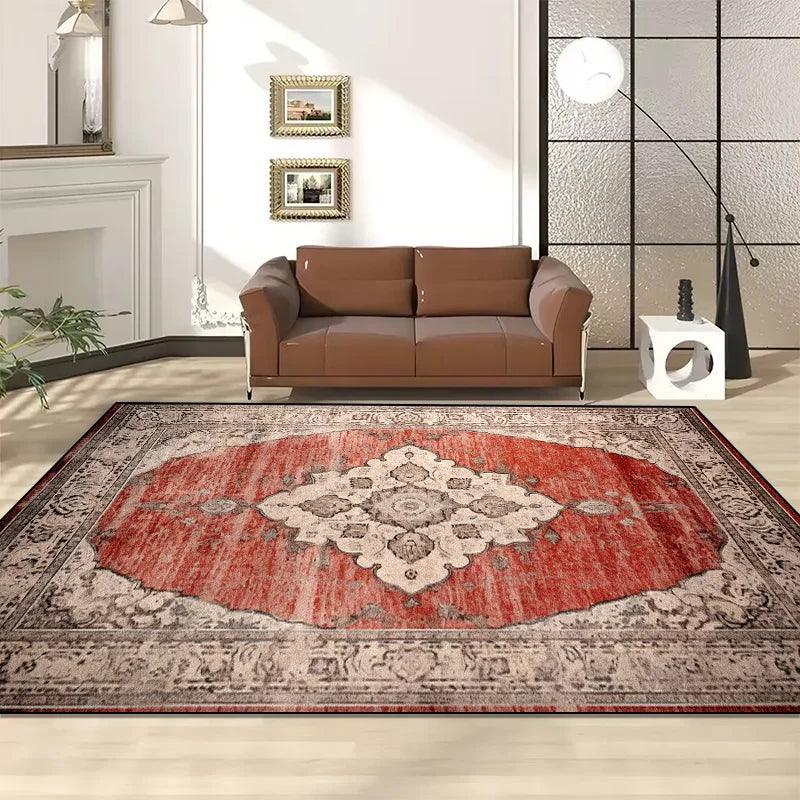 Ce tapis de sol en textile présente un motif ornemental traditionnel aux couleurs orangées et beiges, harmonieusement assorti au canapé en cuir brun et à l'environnement de la pièce.