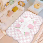 Une jolie couverture de lit pour bébé avec des motifs de pommes roses et blanches sur un fond à carreaux, créant une atmosphère douce et apaisante pour la chambre de l'enfant.