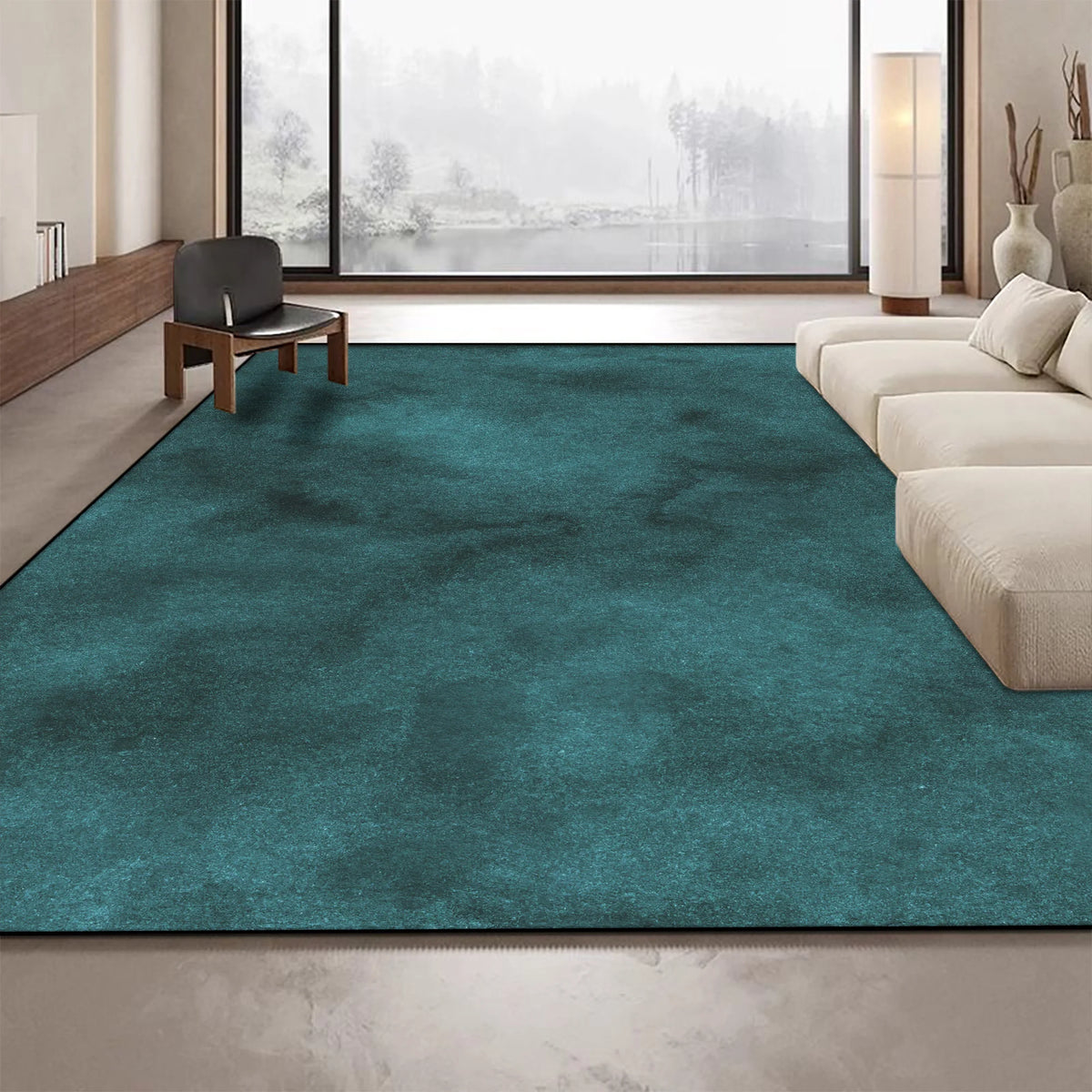 Ce grand tapis vert foncé occupe une grande partie du sol spacieux et éclairé d'un intérieur moderne, avec de larges fenêtres offrant une vue sur un paysage enneigé à l'extérieur.