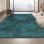 Ce grand tapis vert foncé occupe une grande partie du sol spacieux et éclairé d'un intérieur moderne, avec de larges fenêtres offrant une vue sur un paysage enneigé à l'extérieur.