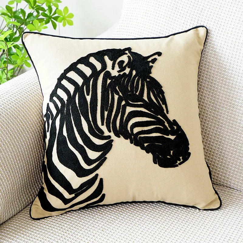 Un coussin décoratif avec un motif zébré noir et blanc, décorant un canapé.