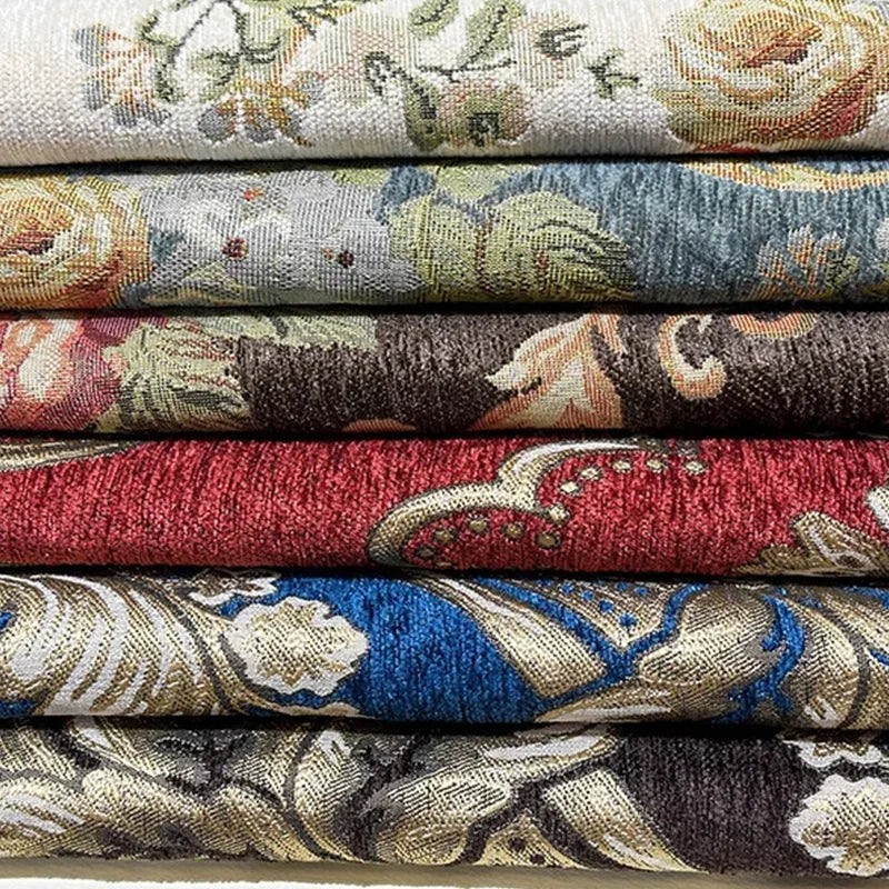 Des rouleaux de tissus d'ameublement aux motifs floraux et ornementaux dans diverses teintes.